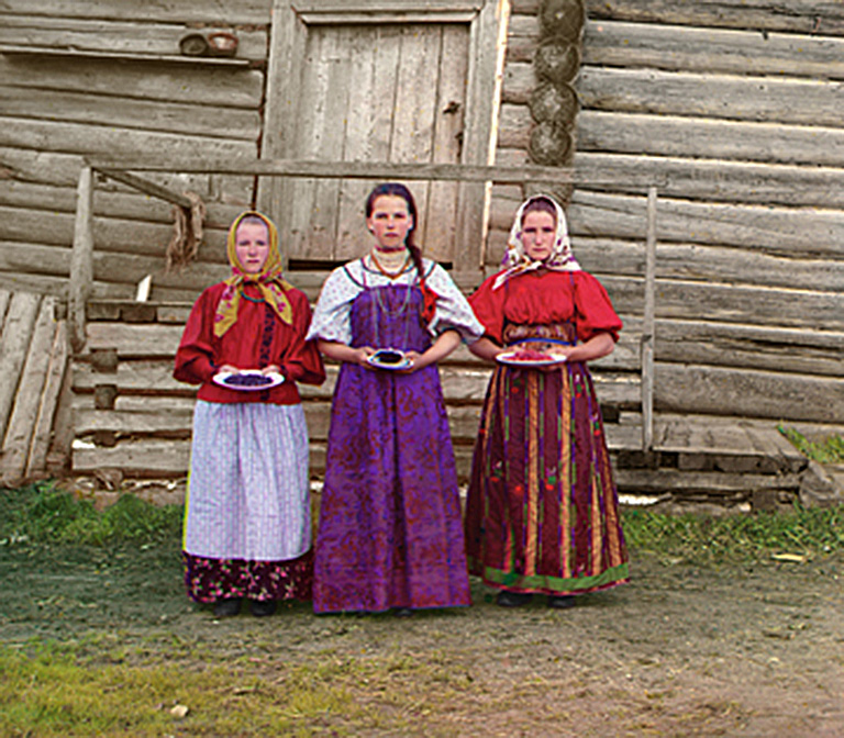 "Early twentieth-century photograph of three Russian peasant women dressed in colorful scarves and skirts"